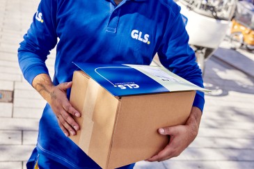 Paketversand Deutschland Zusteller mit Paket in der Hand