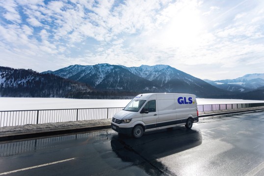 GLS delivery van drives between a forest and a field