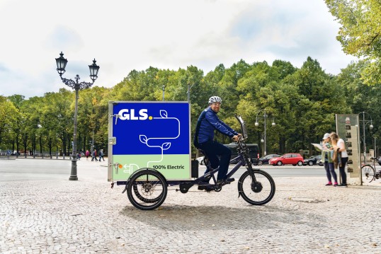 GLS van driving over a bridge in a town