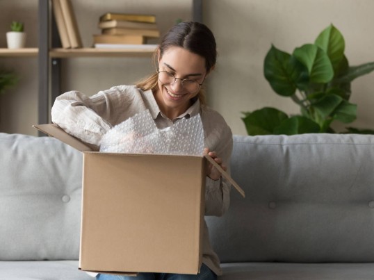 happy woman is opening her parcel