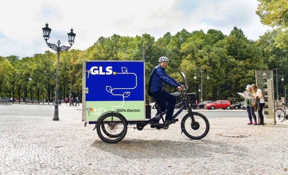 Curier GLS pe bicicletă electrică în parc Curier GLS pe bicicletă electrică în parc