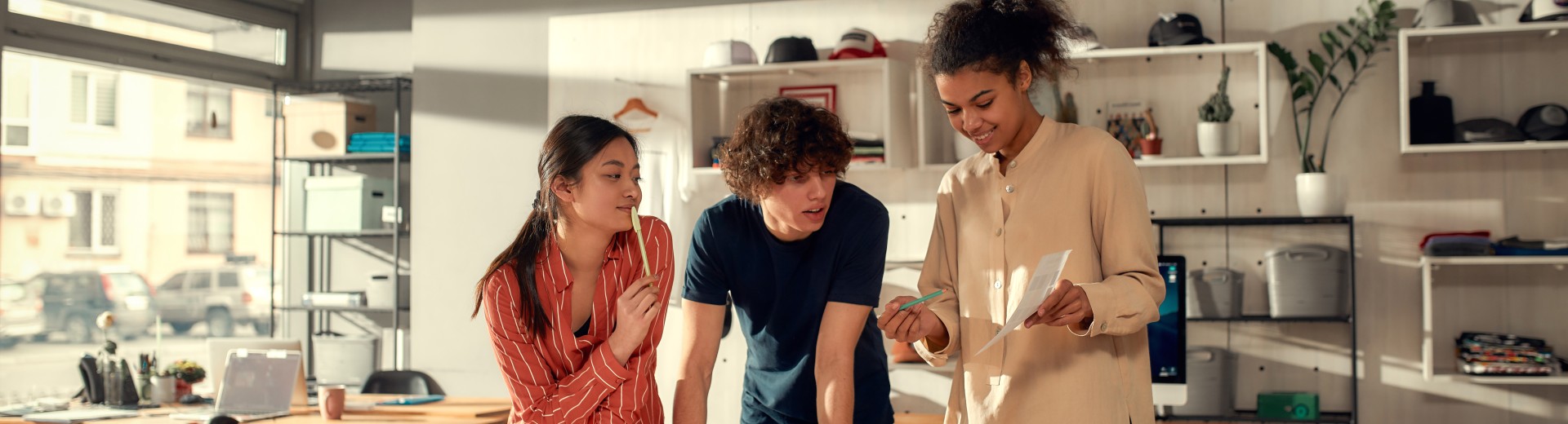 3 angajați tineri lucrând împreună la un proiect  3 angajați tineri lucrând împreună la un proiect