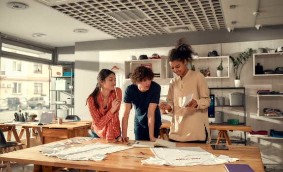 3 angajați tineri lucrând împreună la un proiect  3 angajați tineri lucrând împreună la un proiect