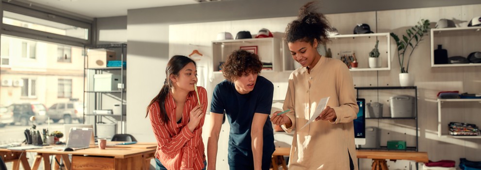 3 angajați tineri lucrând împreună la un proiect  3 angajați tineri lucrând împreună la un proiect