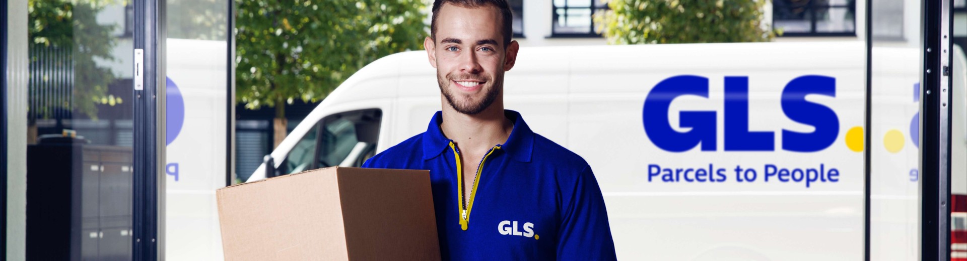 GLS courier delivers a parcel to an office building
