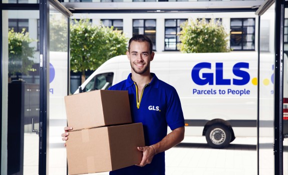 GLS courier delivers a parcel to an office building