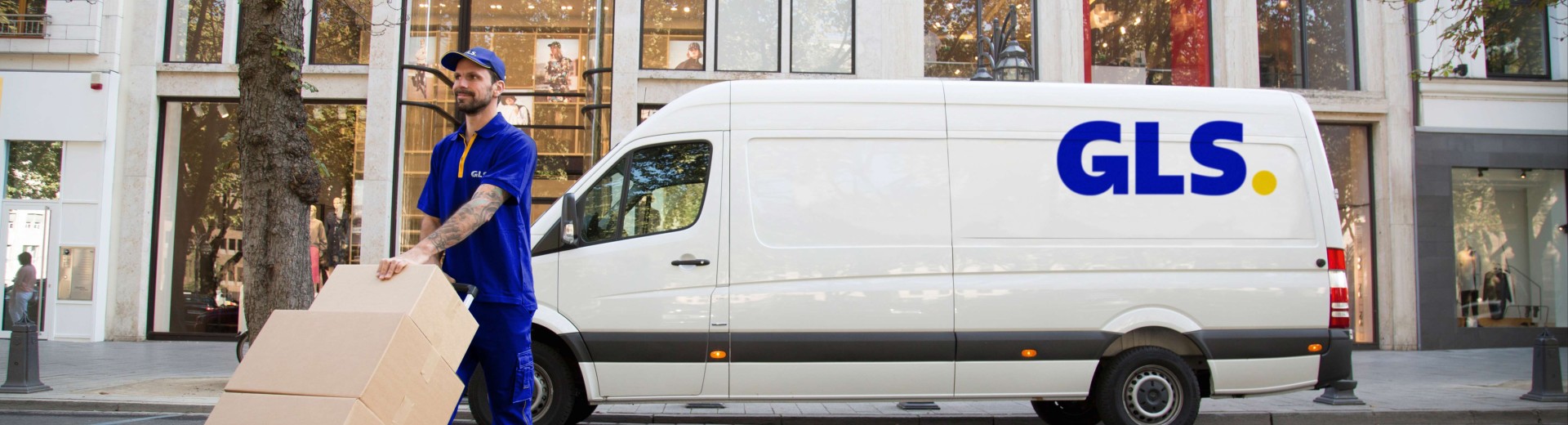 GLS courier handling parcels with a GLS van in the background