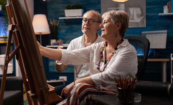 Older couple painting on canvas
