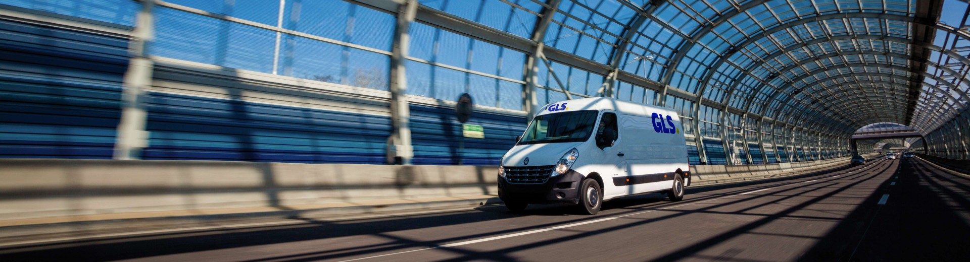 A GLS van is driving through a covered bridge