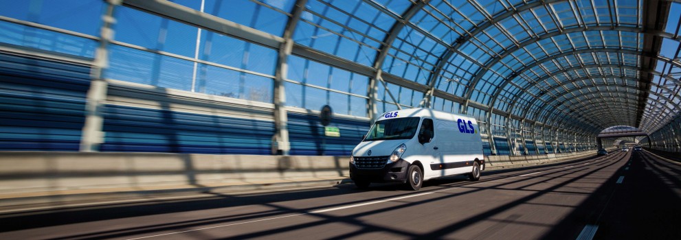 A GLS van is driving through a covered bridge