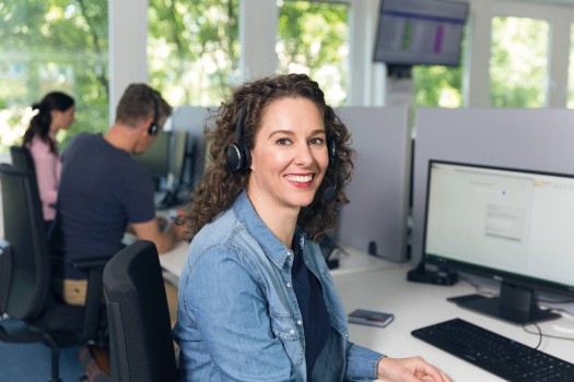 An employee in the contact center is assisting a customer over the phone