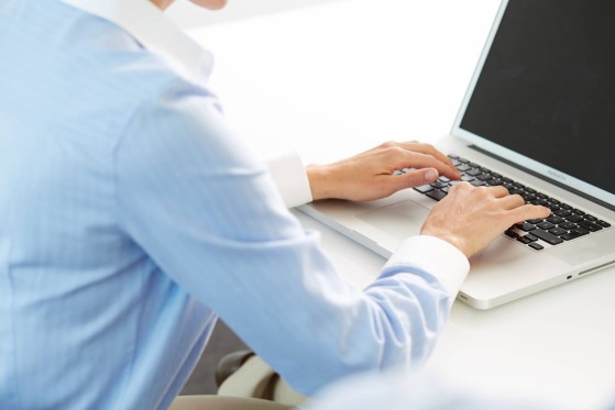 Man in shirt typing on laptop