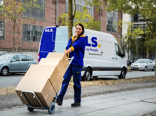 BusinessSmallParcel delivered by GLS female courier in the street